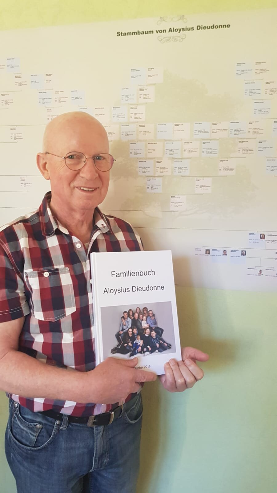Aloysius Dieudonne hält das Familienbuch der Familie Dieudonné in den Händen